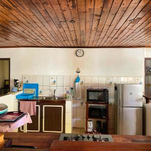 eine Küche mit einem Kühlschrank und einer Uhr an der Wand in der Unterkunft Villa Madirokely in Nosy Be