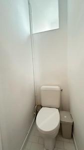 a white bathroom with a toilet and a trash can at Coquet Studio Refait a Neuf en Avril 2024 in Paris