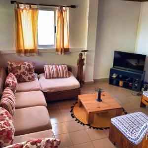 ein Wohnzimmer mit einem Sofa und einem Tisch in der Unterkunft Villa Madirokely in Nosy Be