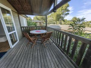 a patio with a table and chairs on a deck at Chalet Agde, 3 pièces, 6 personnes - FR-1-607-59 in Agde