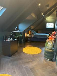 Zimmer im Dachgeschoss mit einem Bett und einer Vase aus Blumen in der Unterkunft Boutique Hotel de Bungelaer in Beers