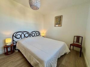 1 dormitorio con 1 cama blanca y 2 sillas en Appartement Quiberon, 2 pièces, 4 personnes - FR-1-478-191, en Quiberon