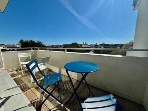 una mesa azul y sillas en el balcón en Appartement Quiberon, 2 pièces, 4 personnes - FR-1-478-191, en Quiberon