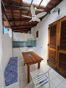 una cucina con tavolo in legno e ventilatore a soffitto di Residence Al Mare a Vulcano