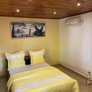 ein Schlafzimmer mit einem Bett und einem Bild eines Dinosauriers in der Unterkunft Villa Madirokely in Nosy Be