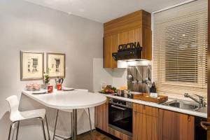 cocina con mesa blanca y fregadero en Feeling Home Lugano - Happy Rentals, en Canobbio