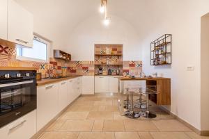 a kitchen with white cabinets and a tile floor at Palazzo Biscilia with private pool - Happy Rentals in Bisceglie