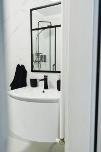 a bathroom with a white sink and a mirror at Artec Magnolia Apartment in Sibiu