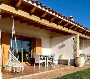 um pátio com uma mesa e cadeiras numa casa em Herdade Monte Do Sol em Aljezur