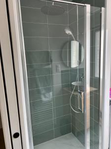 um chuveiro com uma porta de vidro na casa de banho em La Dunette, appt cozy à 150 m de la plage em Merlimont