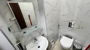 a white bathroom with a sink and a toilet at شقق عمو سامي بغرفة نوم 1 in Amman +5 photos