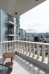 a balcony with a white railing and a table at Luxurious Mamu Apartment in Batumi