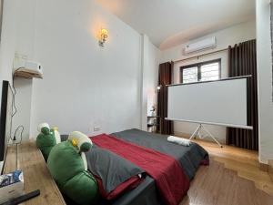 ein Schlafzimmer mit einem großen Bett und einer Leinwand in der Unterkunft Pan Housing Hostel & Residence in Hanoi