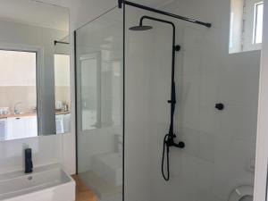 y baño con ducha y puerta de cristal. en Villa Calliope, en Himare