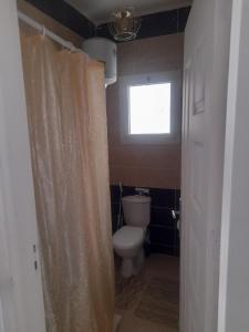 a bathroom with a toilet and a window at Alfayrouz house in Hurghada