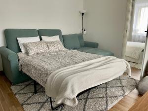 ein Schlafzimmer mit einem Bett und einem Sofa mit einer Decke in der Unterkunft Uus korter väga heas asukohas in Pärnu