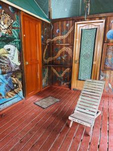 a rocking chair on a wooden deck with a mural at Jungle Lodge with lookout tower in Pucallpa