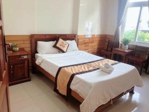 sypialnia z 2 łóżkami i oknem w obiekcie HOÀNG GIA BẢO KON TUM w mieście Kon Tum