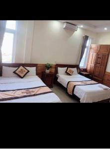 pokój z 2 łóżkami w pokoju w obiekcie HOÀNG GIA BẢO KON TUM w mieście Kon Tum