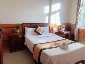 1 dormitorio con 2 camas y toallas. en HOÀNG GIA BẢO KON TUM, en Kon Tum