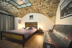 a bedroom with a bed and a brick wall at La Chapelle Industrielle in Issenheim
