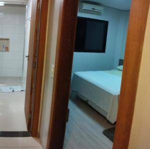 ein kleines Schlafzimmer mit einem Bett und einem Fenster in der Unterkunft Quarto Central Ótimo Custo Benefício in Dourados