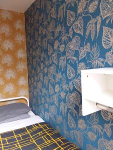 a bedroom with a bed with a blue and white wallpaper at IVY House in Edinburgh