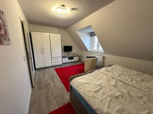 1 dormitorio con cama y alfombra roja en GuestHouse Bielefeld - Brake, en Bielefeld