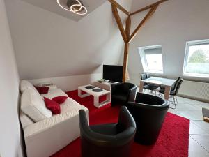 sala de estar con sofá blanco y alfombra roja en GuestHouse Bielefeld - Brake, en Bielefeld