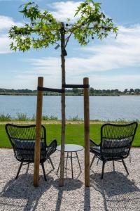 twee stoelen en een tafel naast een boom bij Boutique Hotel de Bungelaer in Beers