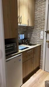 a kitchen with wooden cabinets and a microwave at Suite Urbano en Vigo in Vigo +11 photos