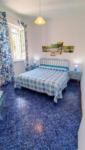 a bedroom with a bed and two tables and a window at Casa del Mare in Ischia
