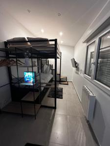 Zimmer mit Etagenbetten und TV. in der Unterkunft Casa Enna in Rueil-Malmaison