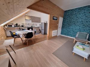 a kitchen and living room with a table and chairs at Grand T2 proche canal de Nantes à Brest. in Châteauneuf-du-Faou