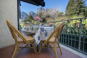 stół i krzesła na balkonie z widokiem na góry w obiekcie Riva Lago e Spiaggia Apartment - Happy Rentals w mieście Riva del Garda +19 zdjęć