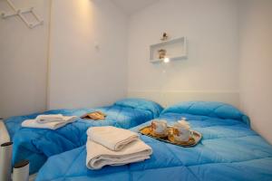 Pokój z 2 niebieskimi łóżkami, ręcznikami i zestawem do parzenia herbaty w obiekcie Riva Lago e Spiaggia Apartment - Happy Rentals w mieście Riva del Garda
