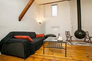 Casa Alla Grotta في آركو: غرفة معيشة مع أريكة سوداء وطاولة