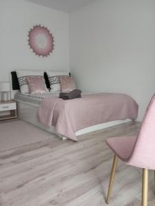 ein Schlafzimmer mit einem Bett und einem rosa Stuhl in der Unterkunft Noclegi U Janusza 536-310-384 in Polańczyk