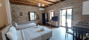 ein Schlafzimmer mit einem Bett und einem TV in einem Zimmer in der Unterkunft Koukouri Suites in Areopoli