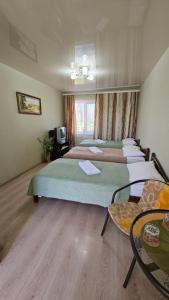 a hotel room with four beds and a television at Domashniy in Kamianets-Podilskyi
