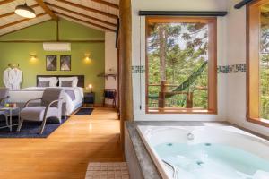 Zimmer mit Badewanne und Schlafzimmer mit Bett in der Unterkunft Pousada Casa Campestre in Gonçalves