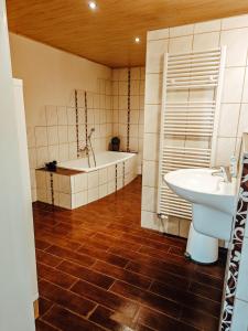 a bathroom with a bath tub and a sink at *groot* Ferienwohnungen lütt & groot in Epenwöhrden