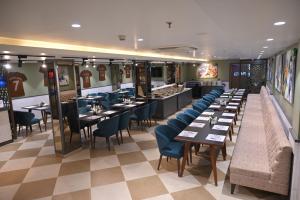 a restaurant with tables and chairs in a room at Ra Vista in Kolkata