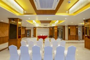 a conference room with white chairs and a projection screen at Ra Vista in kolkata