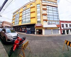 a red motorcycle parked in front of a building at Hotel Xilon Resort Plaza in Pasto