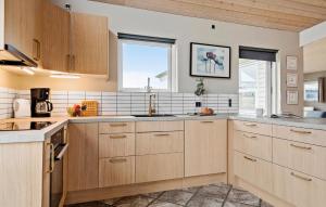a kitchen with wooden cabinets and a sink at Nice Home In Sjølund With Wifi in Sjølund
