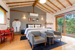 une chambre avec un lit, deux chaises et une table dans l'établissement Pousada Casa Campestre, à Gonçalves 48 autres photos