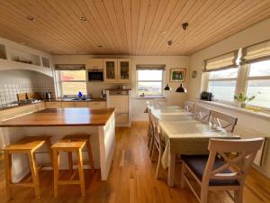 a kitchen with a long table and chairs in it at Sea & Mountain View 4 Bedroom in Leynar +10 photos