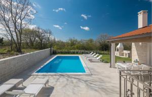 a swimming pool in a backyard with lounge chairs at Beautiful Home In Buje in Buje