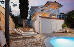 a villa with a swimming pool and a house at Stunning Home In Vrboska With Kitchen in Vrboska